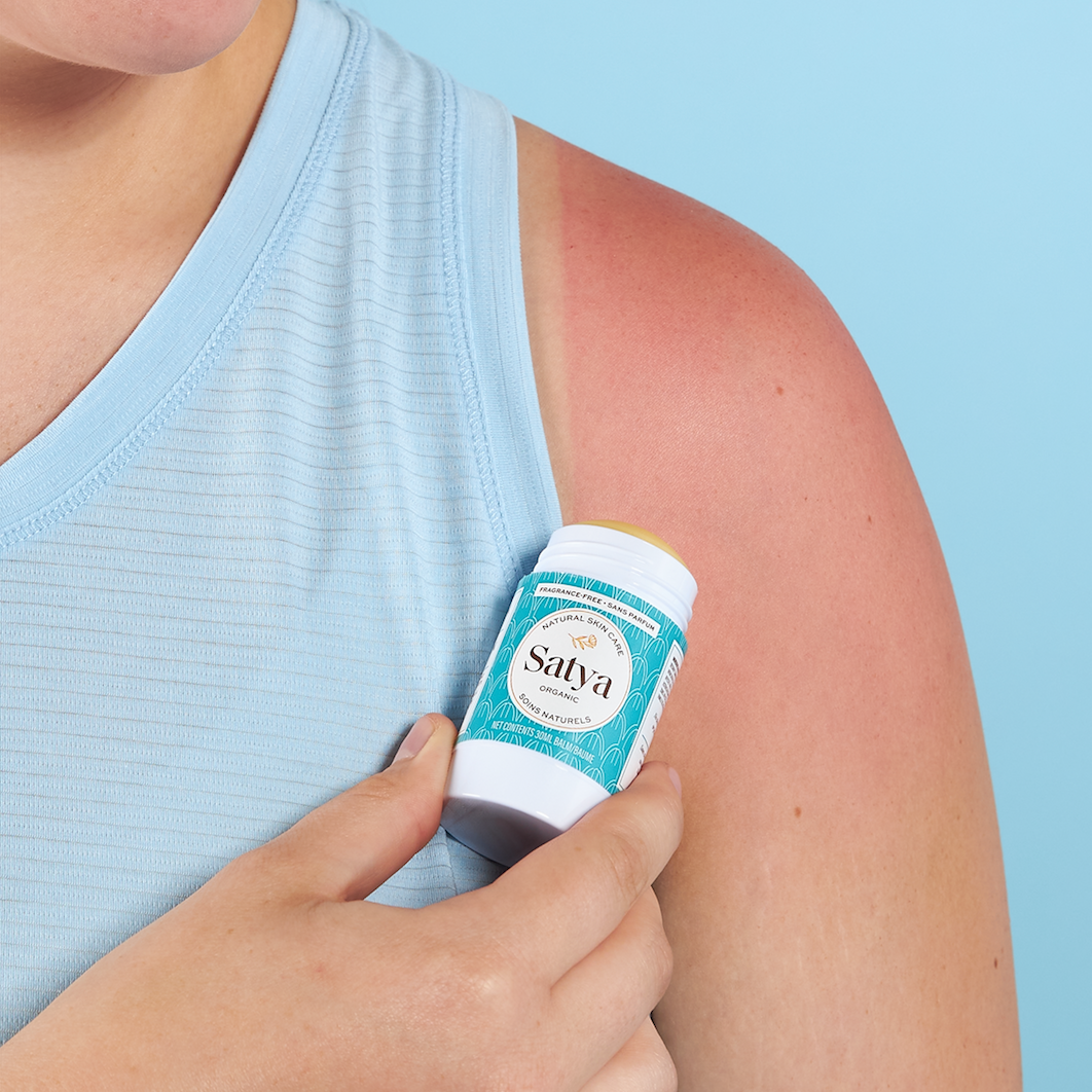 A person applying the Satya Multi Use Easy Glide Stick to their arm as sun aftercare.