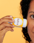 A person applying Satya Eczema Relief Glide Stick to their face.